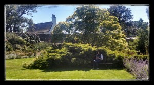 Rosie sitting on garden bench of Inveresk garden Lodge